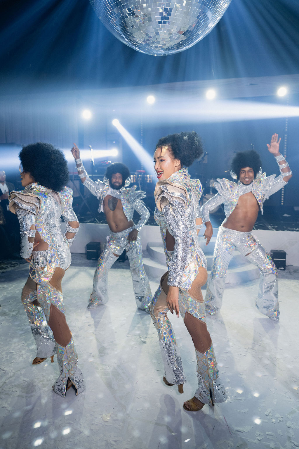 Bailarines con trajes de espejo bajo bola disco